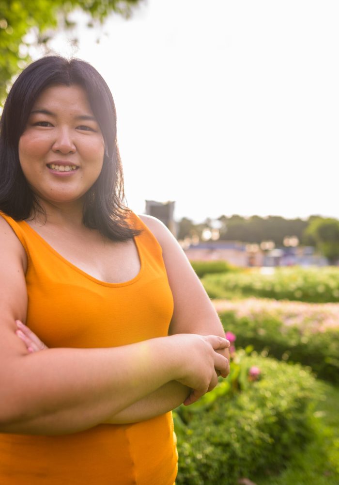 Beautiful Asian woman with arms crossed in park